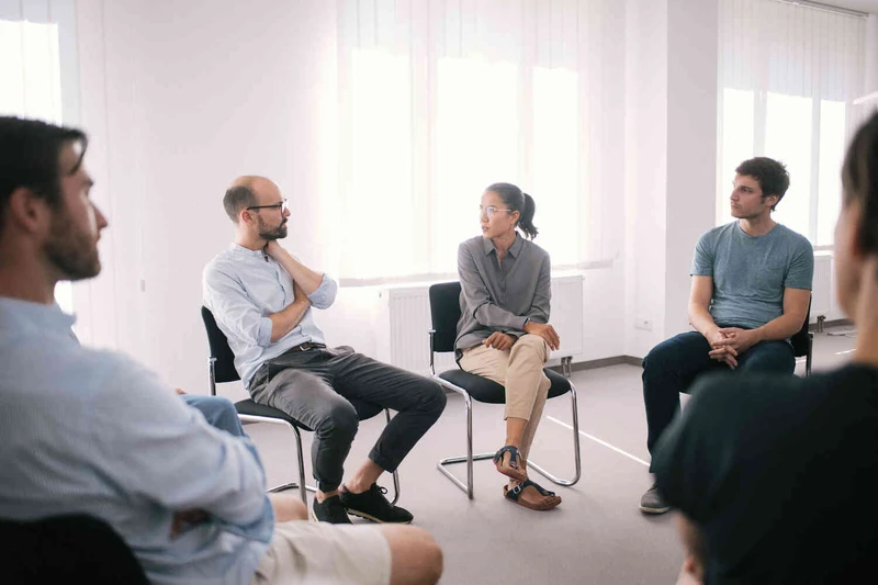 Therapie Gruppe sitzt zusammen in einem hellen wei&szlig;en raum